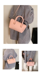 Détail du sac à main rose à texture gaufrée avec poignées et bandoulière