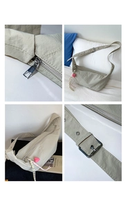 Macro details of nylon crescent bag with heart charm and silver hardware accents