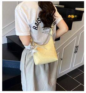 Détail du sac hobo jaune en cuir froissé brillant avec breloque étoile argentée