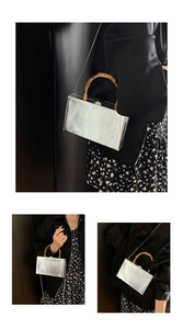 Detail of silver box clutch with bamboo handle and metal chain on black dress