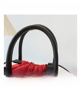 Detail of red woven bucket bag with black handle and drawstring closure detail