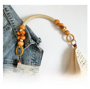 Detail of woven tote handle featuring orange wooden beads and rustic rope accents