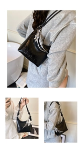 Détails du sac hobo noir brillant avec breloque étoile et texture plissée élégante
