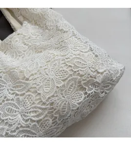 Gros plan sur la dentelle florale blanche et la doublure douce d'un sac cabas
