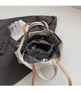 Draufsicht auf das geräumige gestreifte Innenfutter und die Kordelzugtasche dieser Canvas-Tasche