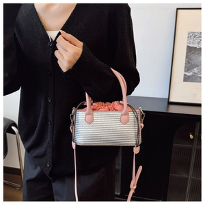 Detail of silver woven handbag with pink leather straps and a drawstring closure