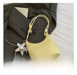 Détail du sac hobo jaune en cuir craquelé avec pendentif étoile argenté brillant