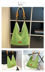 Detail of green hand-woven hobo bag with wooden bead handles and leather tag