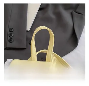 Close-up of comfortable semi-circular handle on creamy yellow faux leather backpack