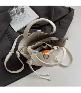 Top view of spacious white crocodile pattern bucket bag interior with items and inner pouch