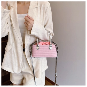 Pink woven mini bucket bag with silver handles shown on white blazer for styling