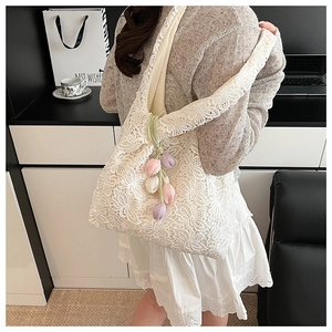 Détail du sac cabas en dentelle florale avec des breloques de tulipes colorées