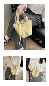 Detail view of yellow croc-effect bucket bag with bear charm and adjustable strap