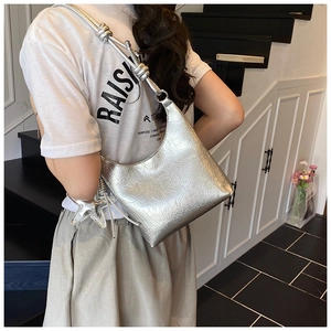 Détail du sac hobo argenté avec texture plissée et accessoire pendentif en étoile