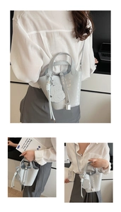 Detail of light blue croc-embossed bucket bag with silver padlock and bear charm detail