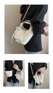 Detail of white crocodile embossed bucket bag with bear charm and inner pouch
