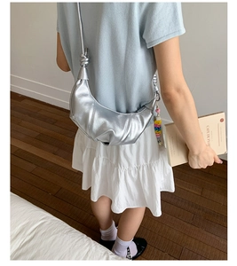 Silver metallic crescent bag with wrinkled texture and colorful bead charms on model