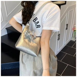 Gros plan sur un sac seau plissé argenté avec texture métallisée et breloque étoile
