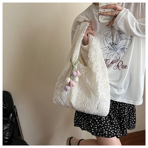 Gros plan du sac cabas en dentelle blanche avec pendentif tulipe coloré