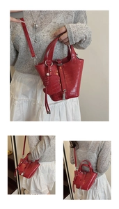 Detail of red crocodile texture bucket bag with metal clasp and bear charm