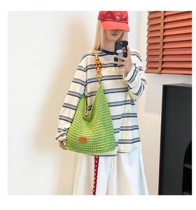 Detail of bright green crochet tote bag featuring wooden bead accent and knit texture
