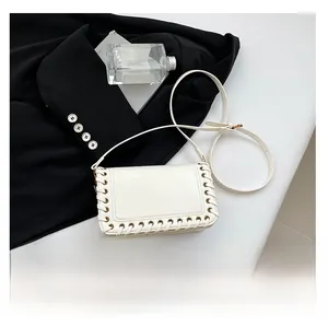 Detailed view of white leather shoulder bag showing size comparison with a smartphone