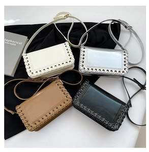 Flat lay of small square woven bags in beige, silver, brown, and black with metal eyelets