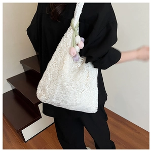 Détail du sac cabas en dentelle blanche avec breloques de tulipes sur la bandoulière