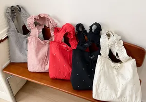 Detail of ruffled shoulder straps and pearl accents on five colorful tote bags