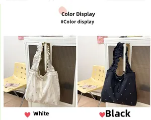 Detail view of large tote bags in white and black with ruffled straps and pearl accents