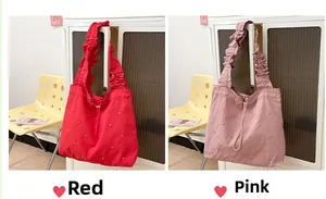 Detailed view of red and pink pleated tote bags with rhinestones and drawstring closure