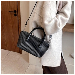 Détail de la texture tissée noire d'un sac cabas minimaliste avec poignée ronde