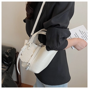 White croc-effect bucket bag detail with adjustable strap and cute bear charm pendant