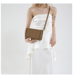 Close-up of vintage brown leather woven crossbody bag detailing on an adjustable strap