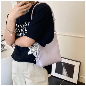 Détail du sac seau lilas présentant un pendentif étoile argentée décoratif sur la bandoulière