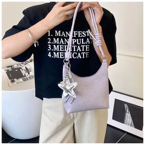 Détail du sac hobo lilas avec pendentif étoile et nœud sur la bandoulière réglable