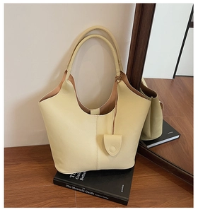 Close-up of cream yellow bucket bag with lychee texture and matching mini pouch
