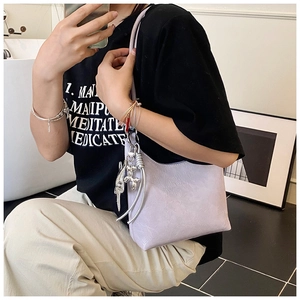 Détail du sac porté épaule lilas en similicuir avec breloques chien ballon argentées