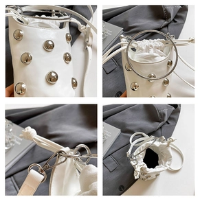 Détails d'un sac seau blanc avec rivets argentés, poignée en métal et fermeture par cordon