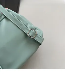 Detail of mint green leather texture and silver metal adjustable buckle hardware