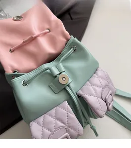 Detail of macaron leather mini backpack showing drawstring closure and magnetic buckle lock