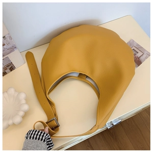 Gros plan du sac hobo jaune gingembre avec texture grainée litchi et boucle argentée