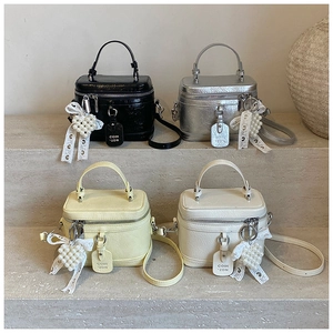 Mini vintage bucket bags in four colors with pearl heart and lace bow charms on stairs