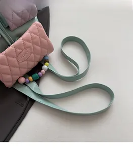 Macro detail of quilted pastel leather bag featuring colorful beads and elegant shoulder strap
