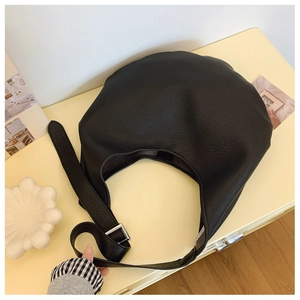 Gros plan détaillé sur la texture grainée d'un sac hobo noir en cuir de qualité