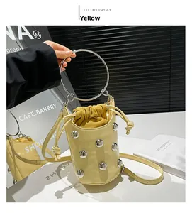 Détail du sac seau jaune à rivets avec poignée anneau métallique et doublure coulissante