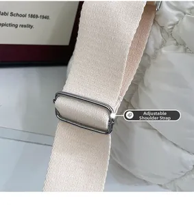 Dettaglio della tracolla regolabile in tela beige con fibbia in metallo su borsa bianca