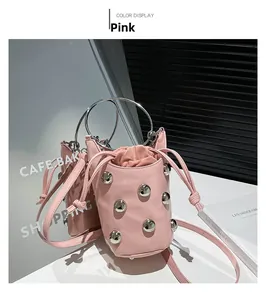 Gros plan du sac seau rose orné de gros clous argentés et d'une poignée en métal