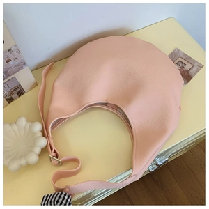 Détail du cuir rose grainé litchi et de la bandoulière réglable sur un sac hobo chic