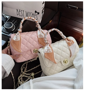 Detailed view of pink and beige quilted chain bags with silk scarf handle decoration
